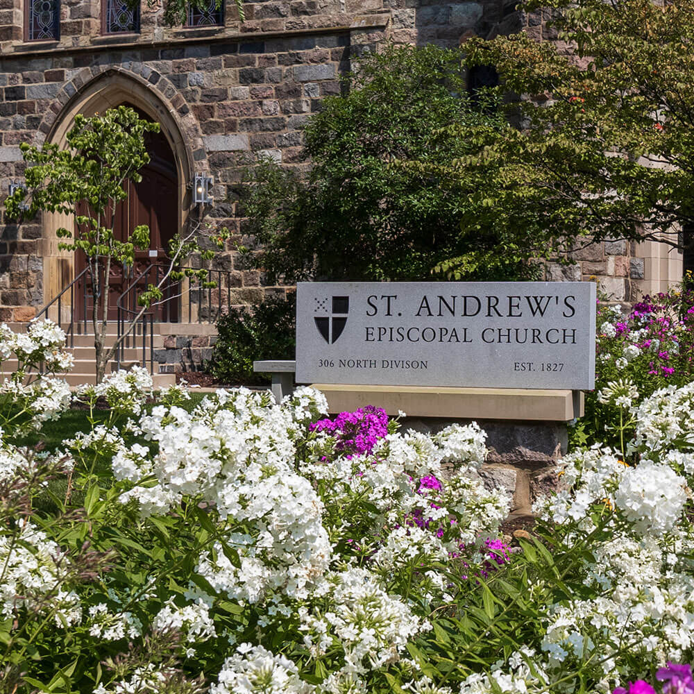 Sign with service times surrounded by flowers